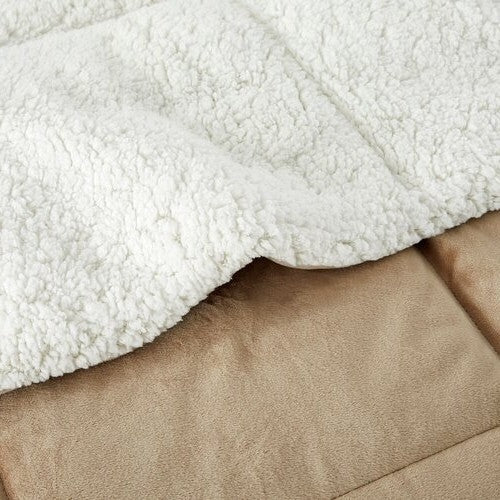 Close-up of plush beige comforter fabric with a soft, sherpa-like underside and smooth outer material